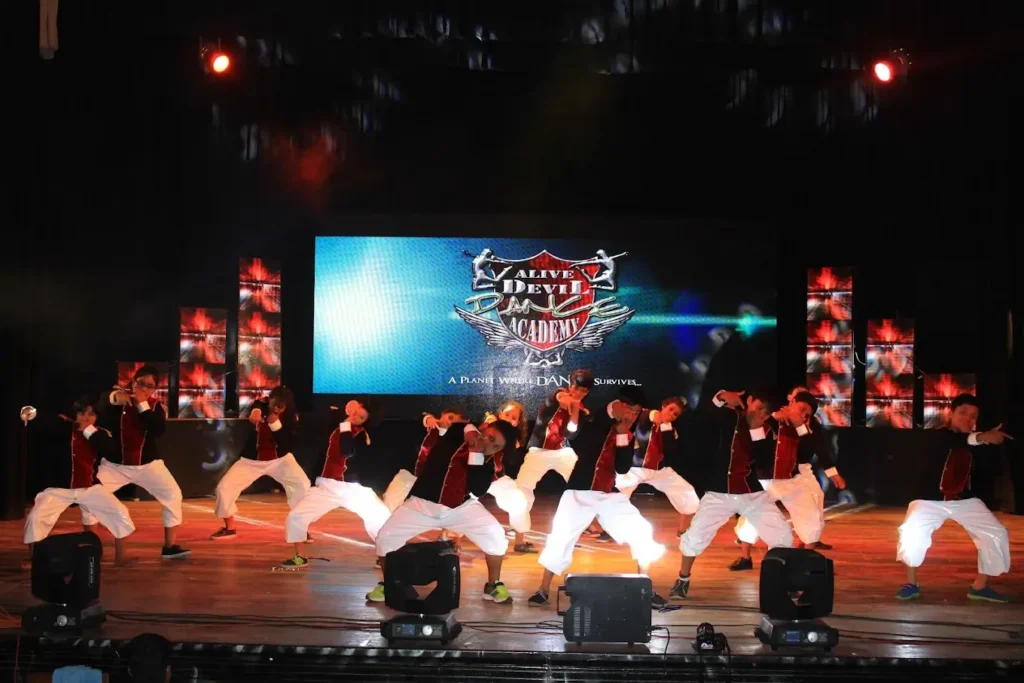 a group of students of a dance academy, performing on stage