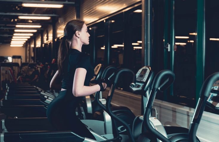Freelance fitness trainer helping clients with exercise routine