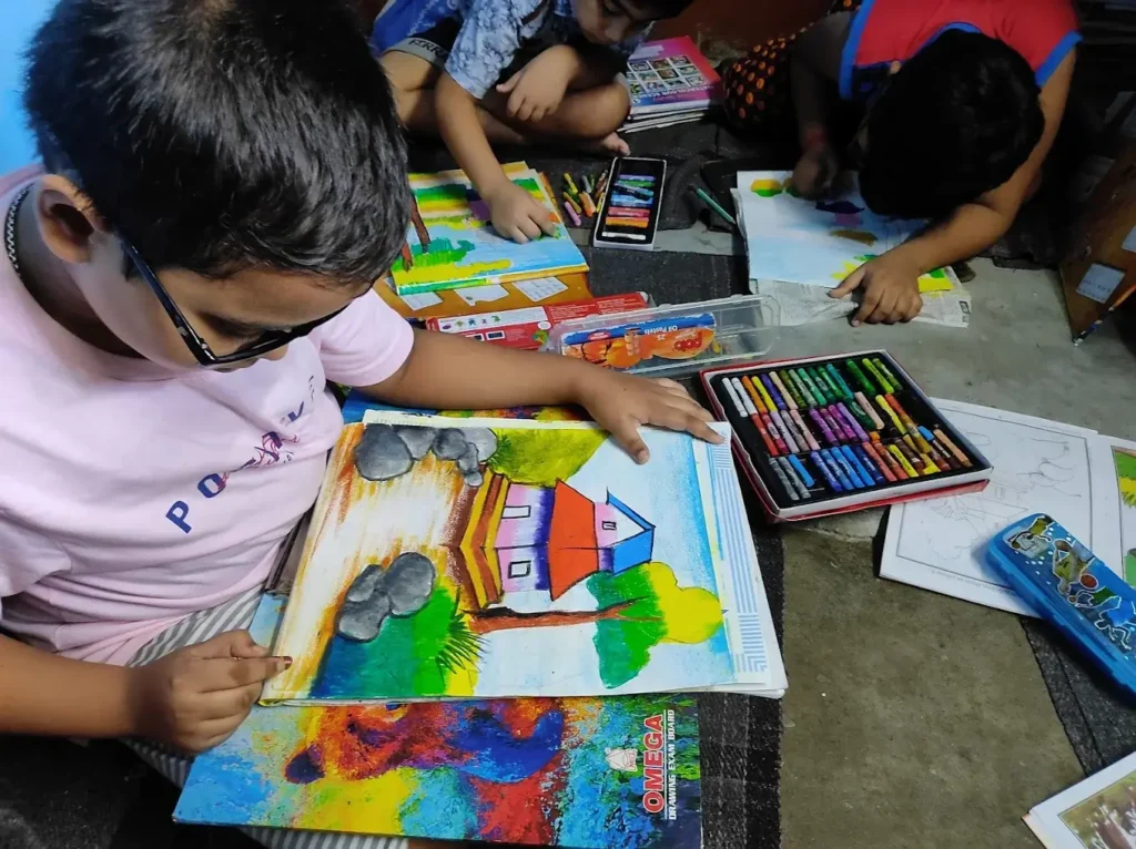 children painting with oil pastel colors on paper